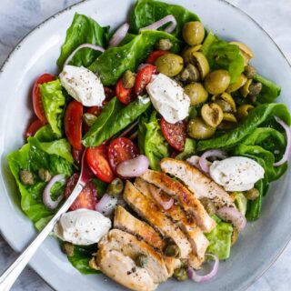 Keto grilled chicken salad in a bowl with dollops of cream cheese on top