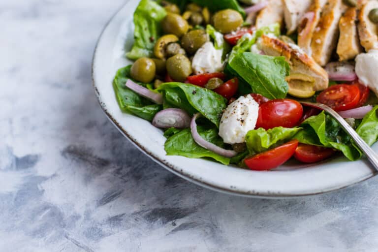 Grilled chicken salad with lettuce and tomatoes in a bowl