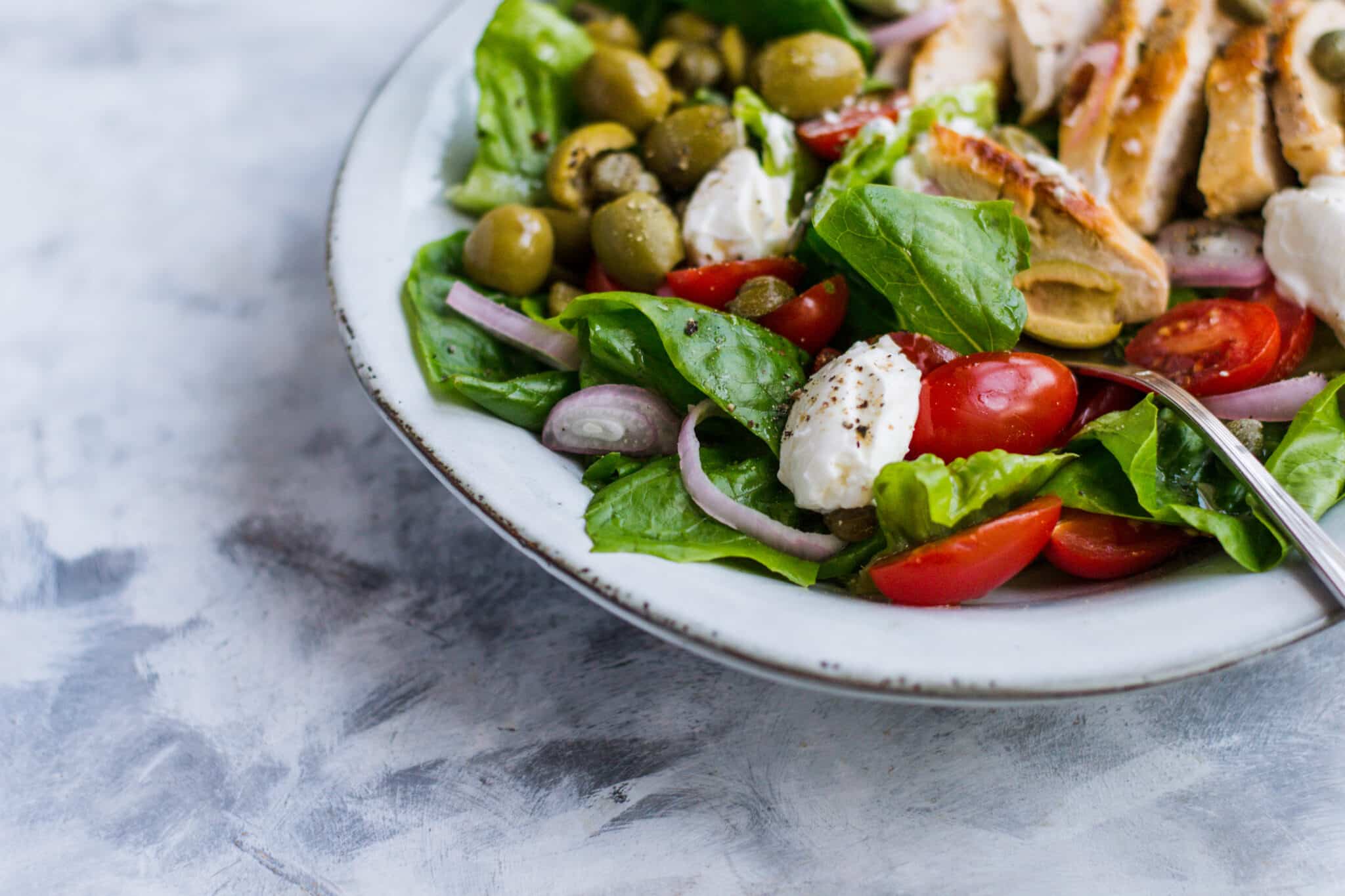 Grilled chicken salad with lettuce and tomatoes in a bowl