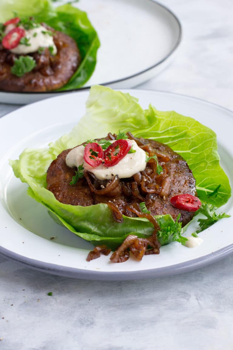Turkey burgers wrapped in lettuce leaves served with sauce and caramelised onions