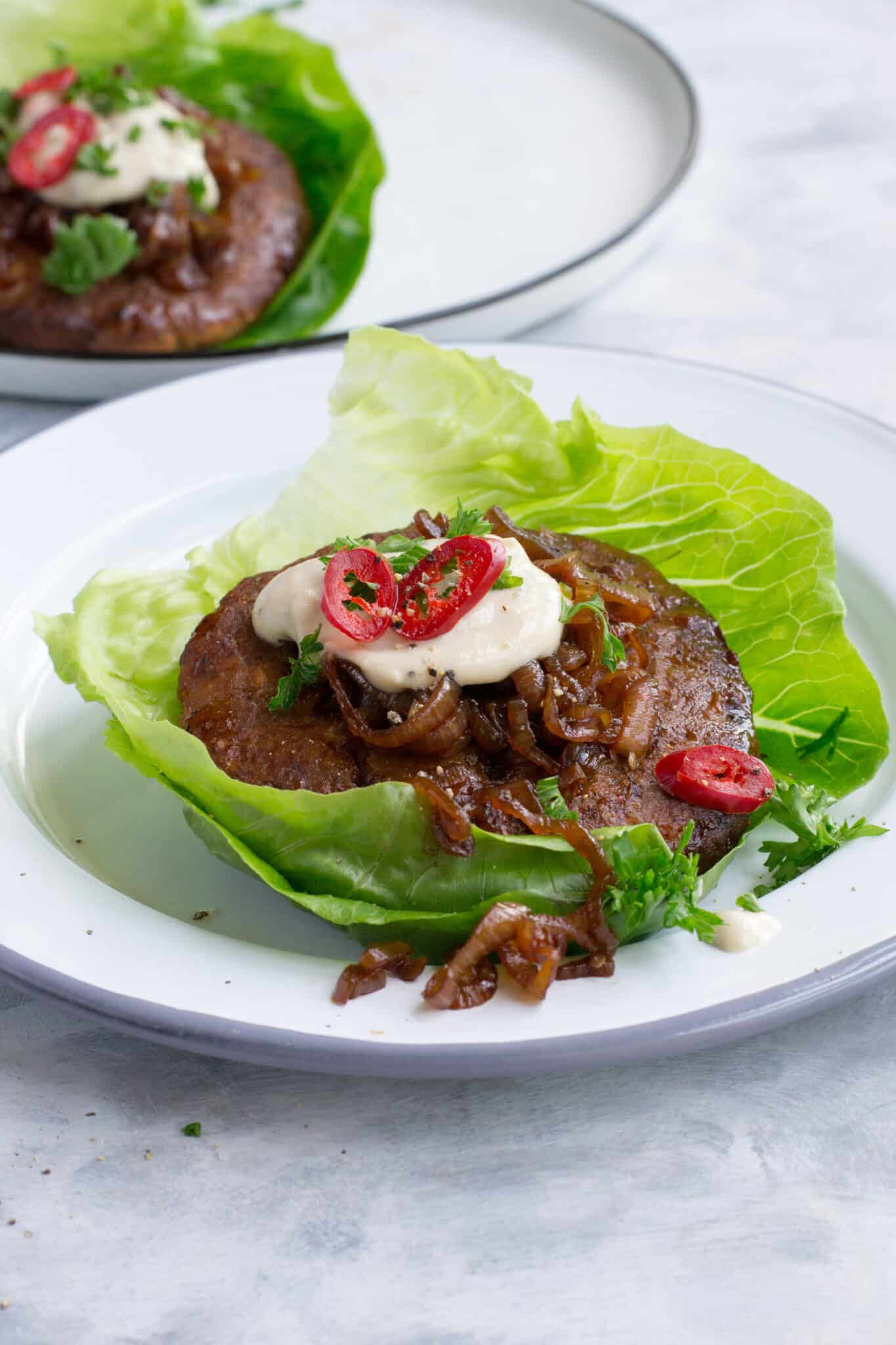 Turkey burgers wrapped in lettuce leaves served with sauce and caramelised onions
