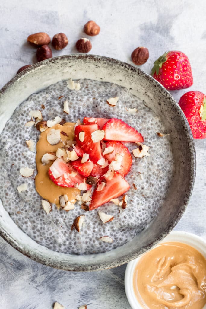Vegan keto chia seed pudding with strawberries and nut butter on top