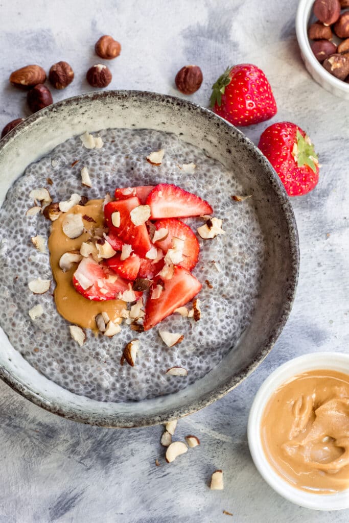 Vegan keto chia seed pudding with strawberries, hazelnuts and nut butter on top