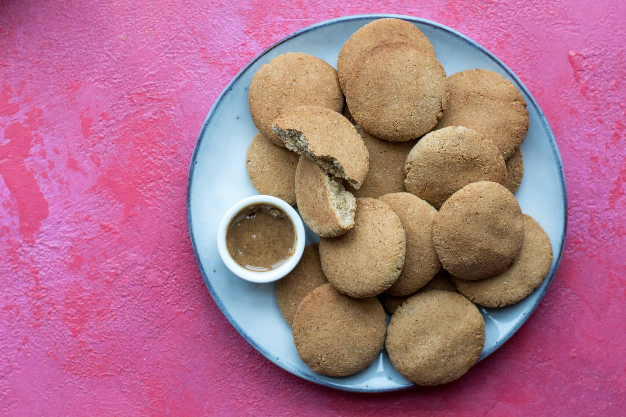 Keto peanut butter cookies and peanut butter in a bowl