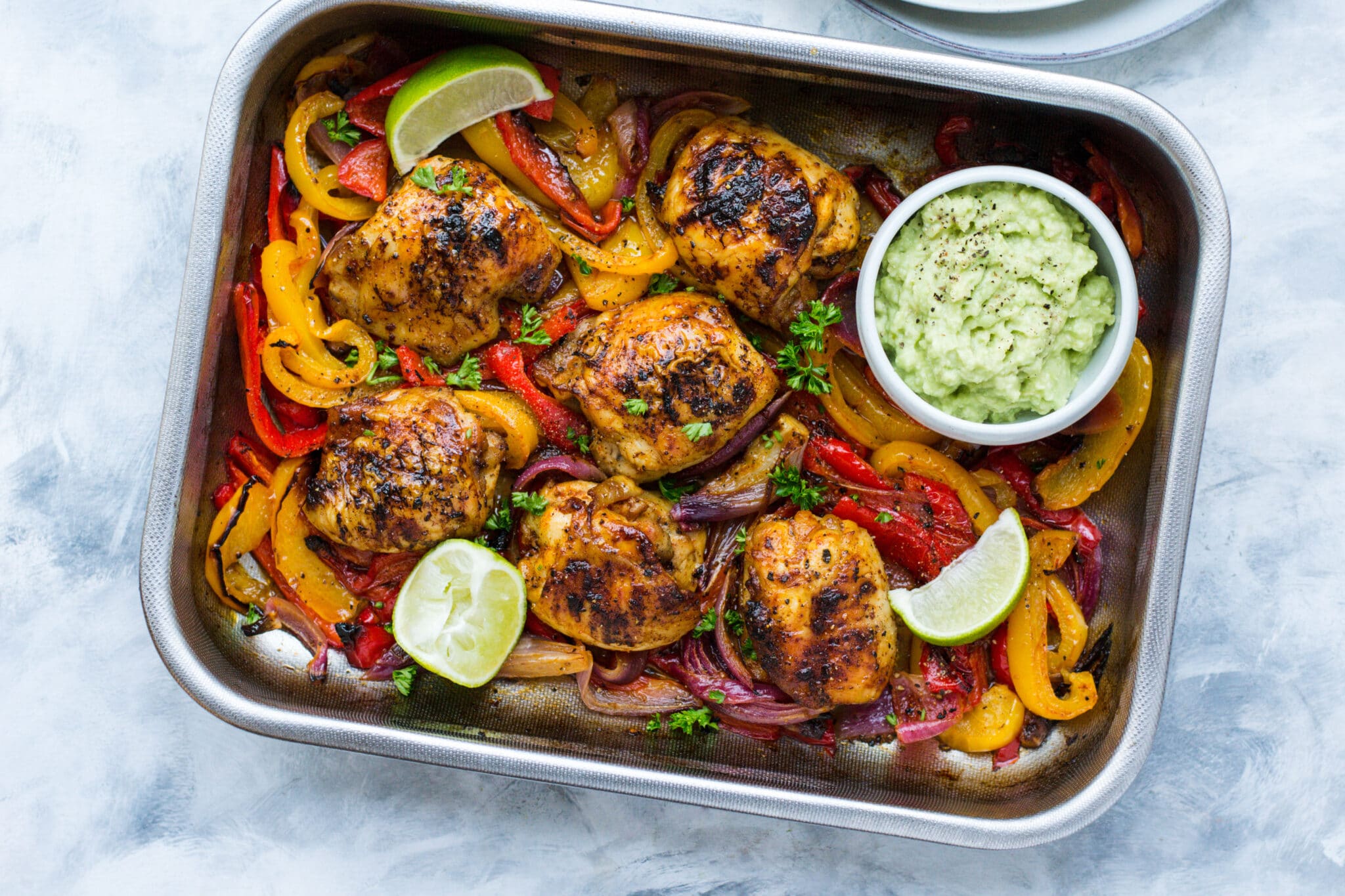 Keto Mexican chicken traybake with avocado and lime wedges