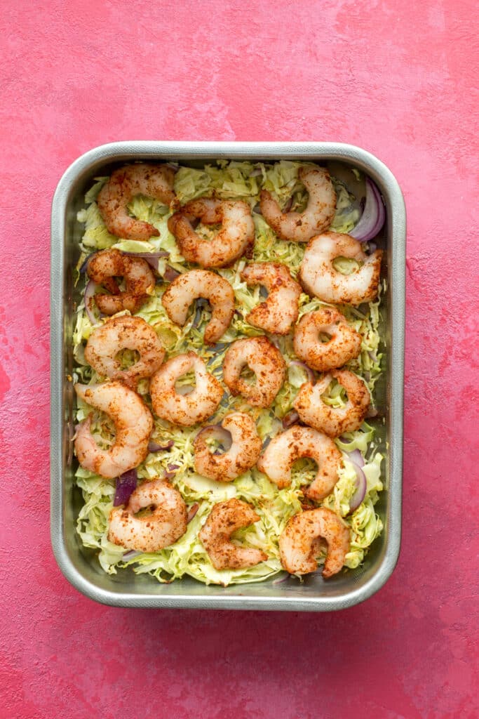 Vegetables and raw shrimp in a baking pan