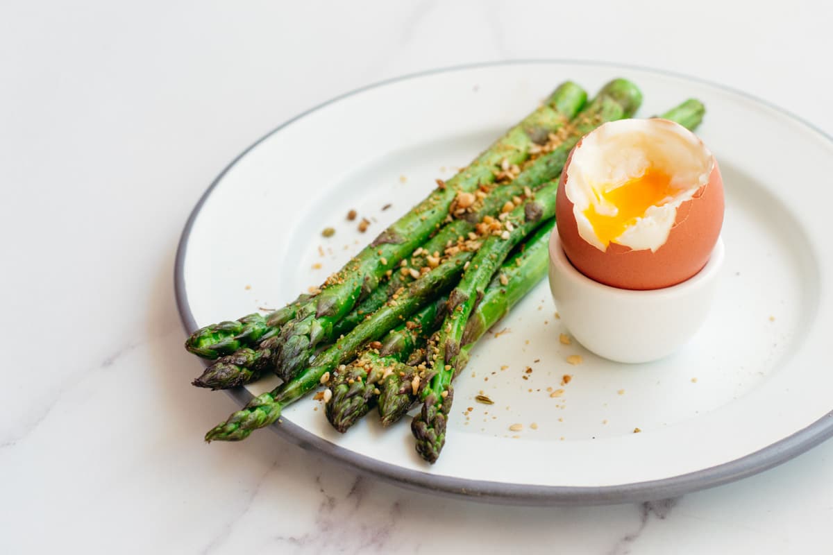 Cooked asparagus and a soft boiled egg