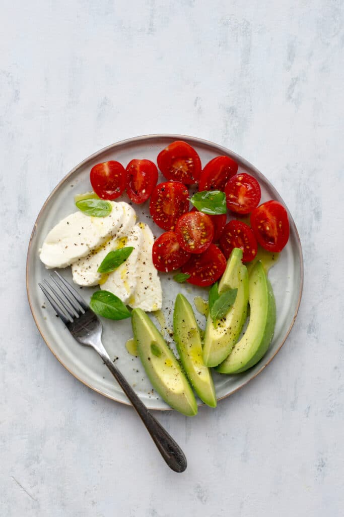 Caprese salad with avocado on a plate